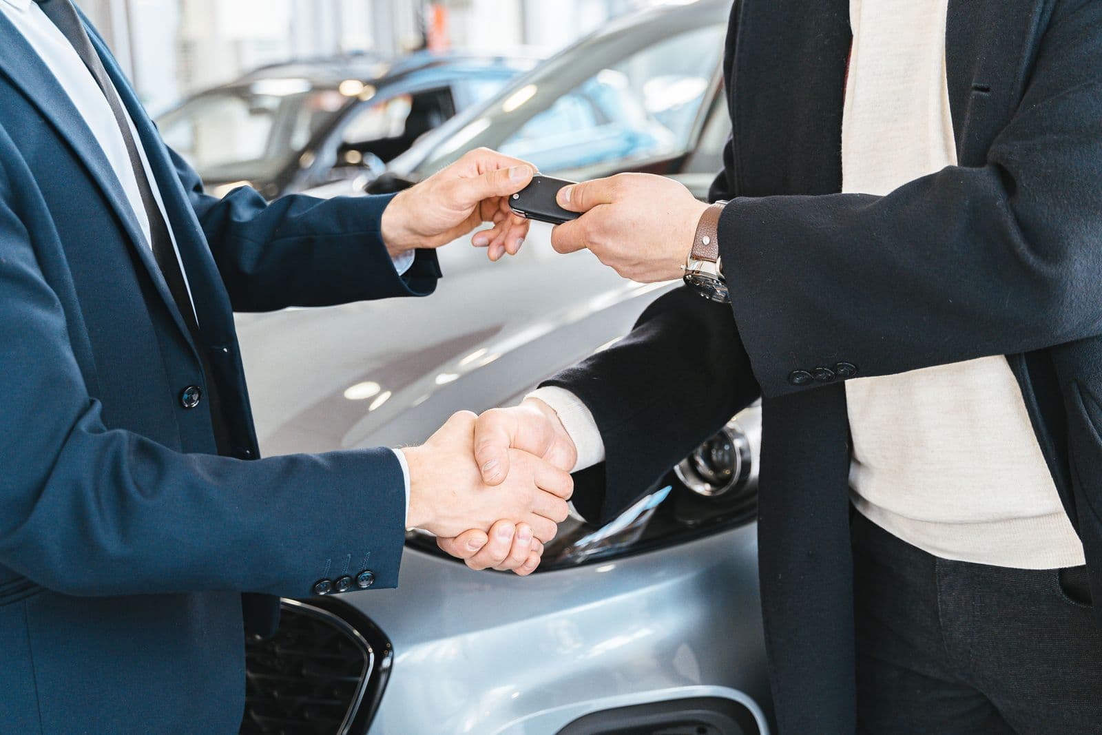 A handshake over a set of keys at a dealership